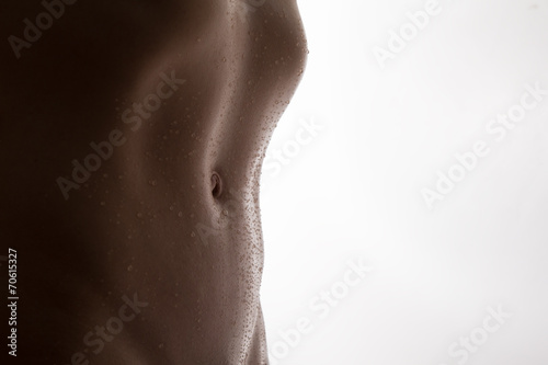Bodyscape of a nude woman with wet stomach and back lighting art photo