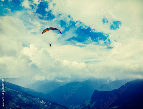 Paraplane in sky above mountains