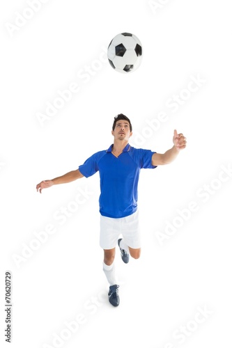 Fit player kicking football