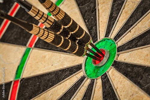 Three darts in bull's eye close up