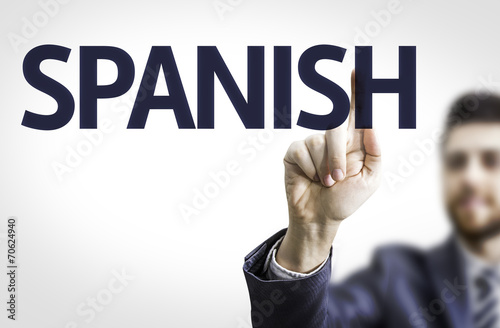 Business man pointing to transparent board with text: Spanish