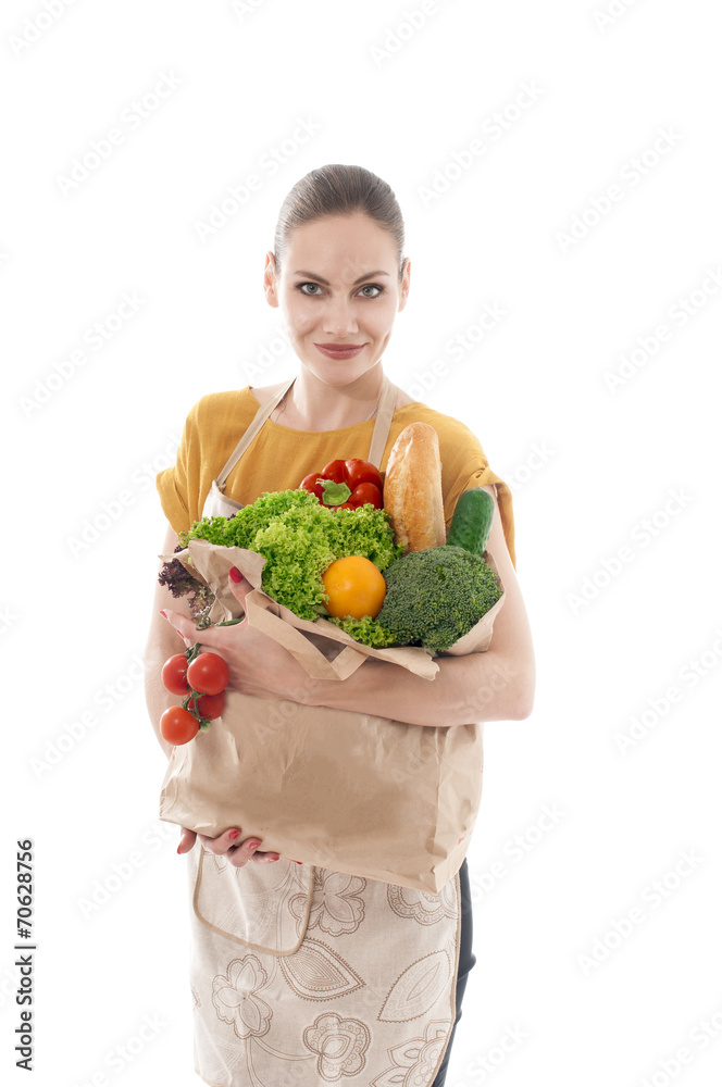 Young housewife holding a grocery bag full of vegetables, isola Young housewife holding a grocery bag full of vegetables, isola