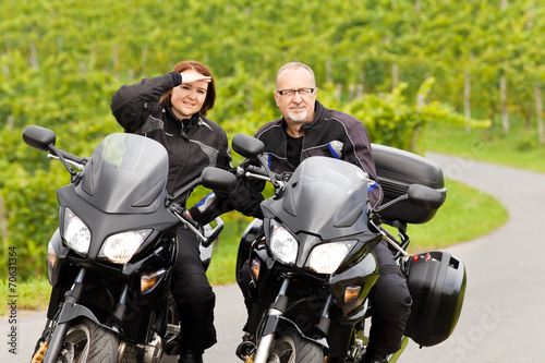 Zweiradfahrer mit Blick in die Kamera auf ihren Motorrädern