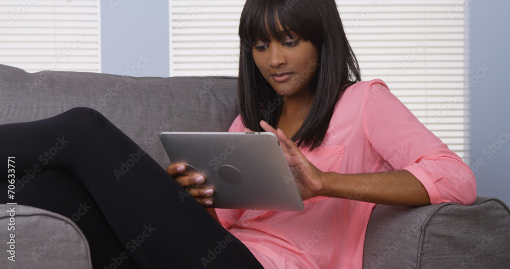 Woman using tablet on couch Woman using tablet on couch