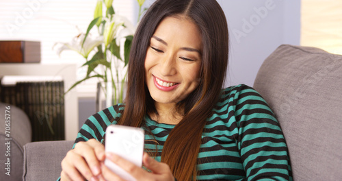 Japanese woman using smartphone on couch