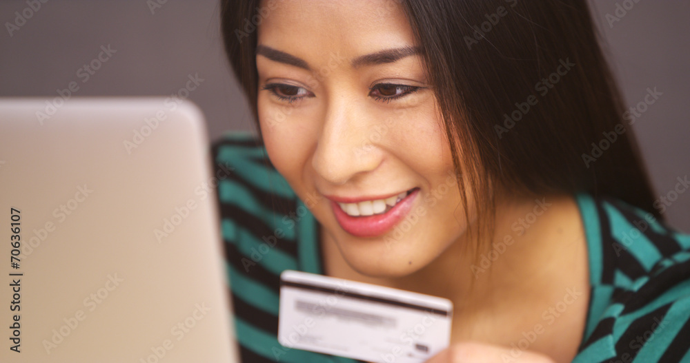 Close up of Japanese woman typing in credit card information Close up of Japanese woman typing in credit card information