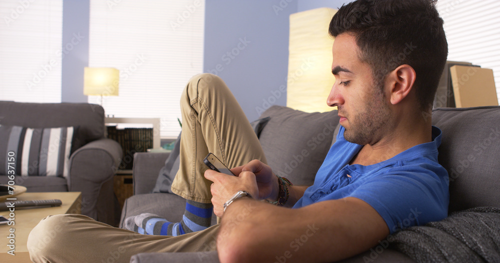 Happy Hispanic man surfing the internet on smartphone Happy Hispanic man surfing the internet on smartphone