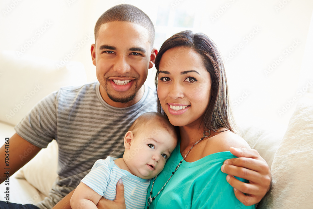 Young Couple Sitting On Sofa Using Digital Tablet