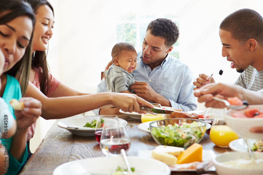 Group Of Friends With Babies Enjoying Meal At Home Together