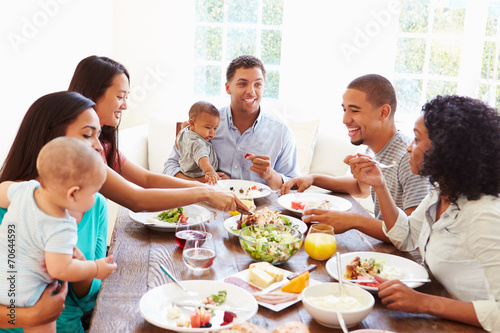 Group Of Friends With Babies Enjoying Meal At Home Together