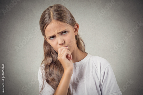 skeptical young girl looking suspicious grey background 