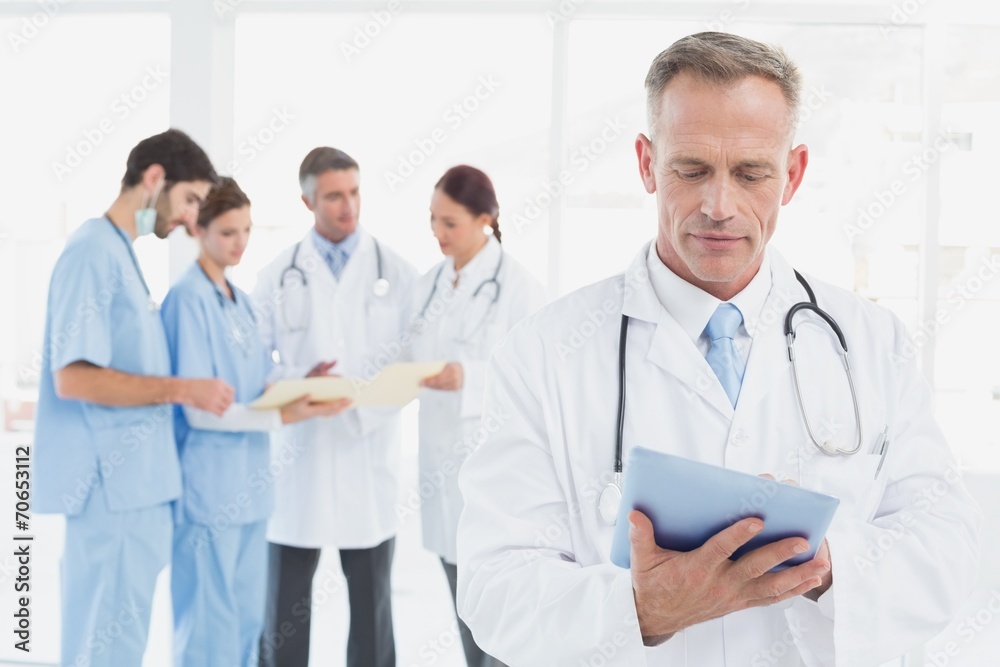 Serious doctor using his tablet Serious doctor using his tablet