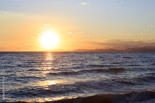 Huge sun sets in the Aegean Sea.