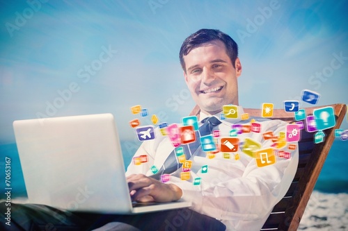 Cheerful young businessman lying on a deck chair