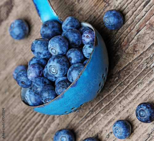 a ladle with blueberries on a table