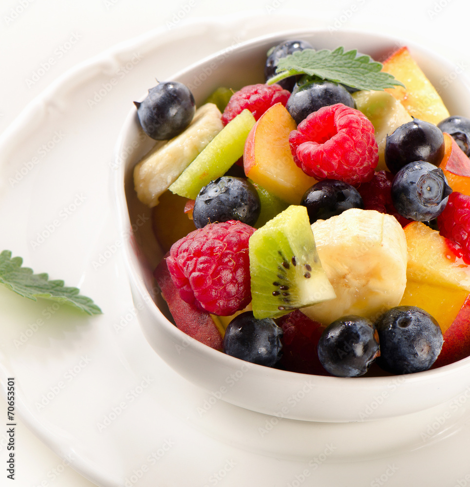 Fresh healthy fruit salad in a white bowl Fresh healthy fruit salad in a white bowl