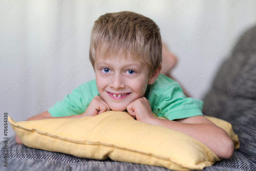 Fototapeta premium süßer kleiner junge liegt auf dem sofa