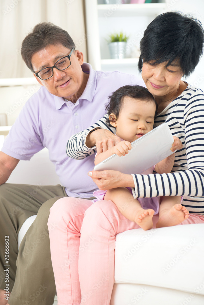 asian senior grand parents teaching grand son with tablet asian senior grand parents teaching grand son with tablet