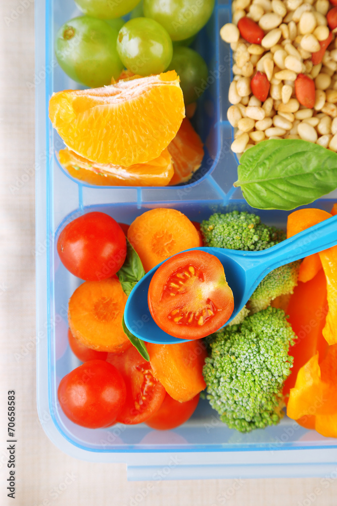 Tasty vegetarian food in plastic box on wooden table Tasty vegetarian food in plastic box on wooden table