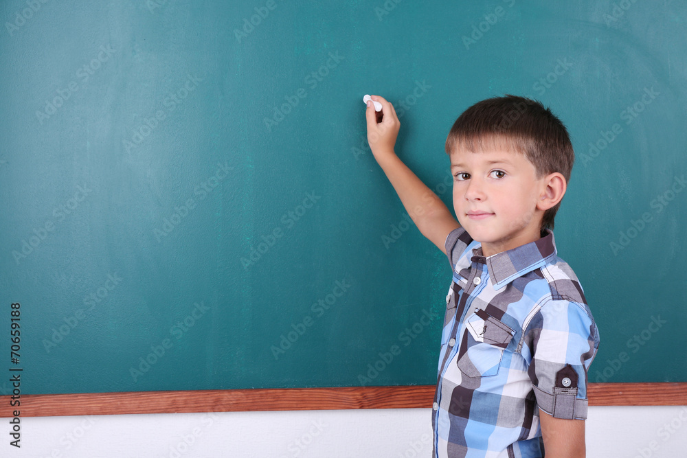 Schoolboy at blackboard in classroom Schoolboy at blackboard in classroom