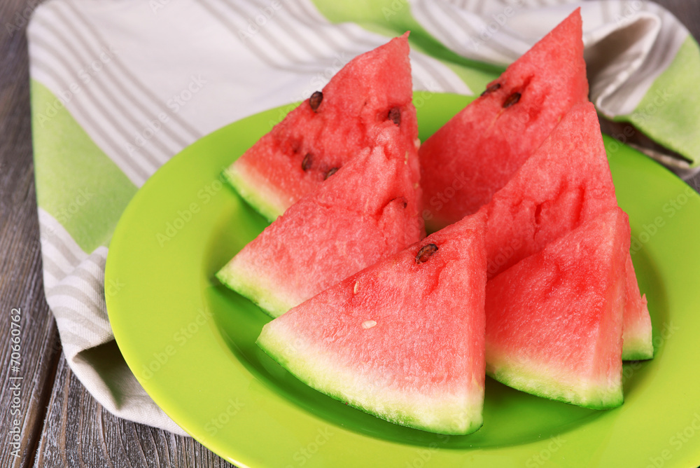 Slices of watermelon on plate on wooden table