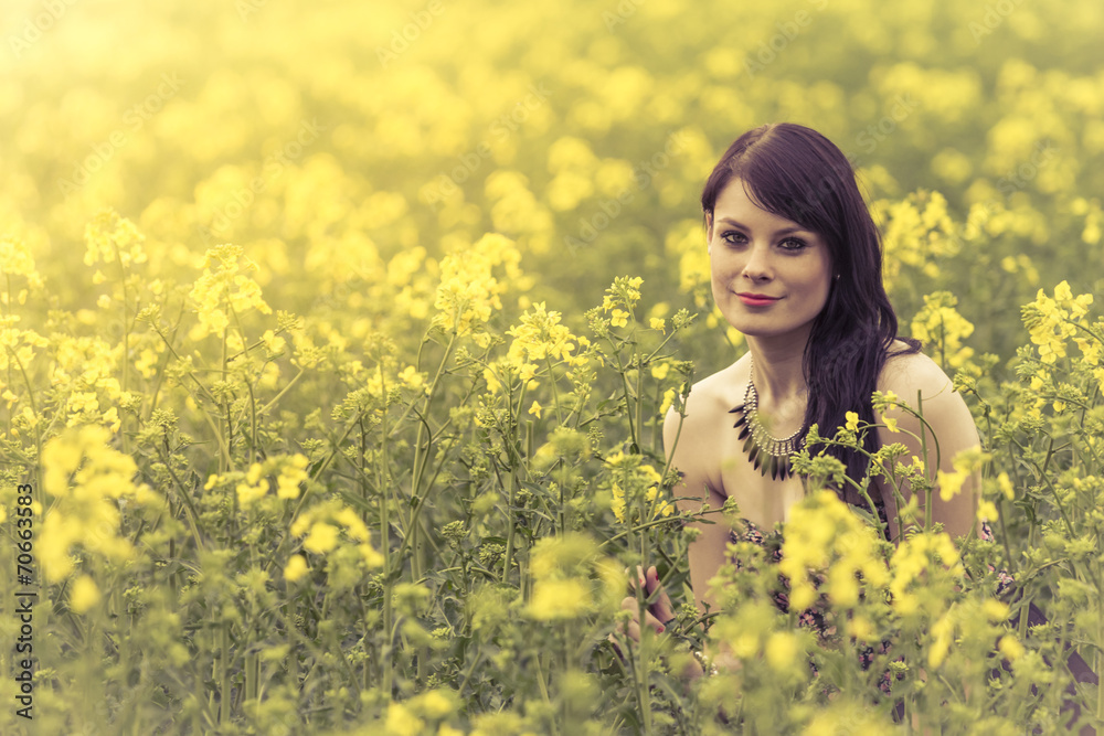 Beautiful woman in meadow of yellow flowers sitting down Beautiful woman in meadow of yellow flowers sitting down