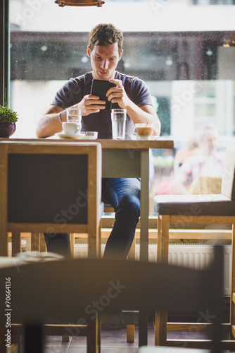 Young man watching tablet in cafe