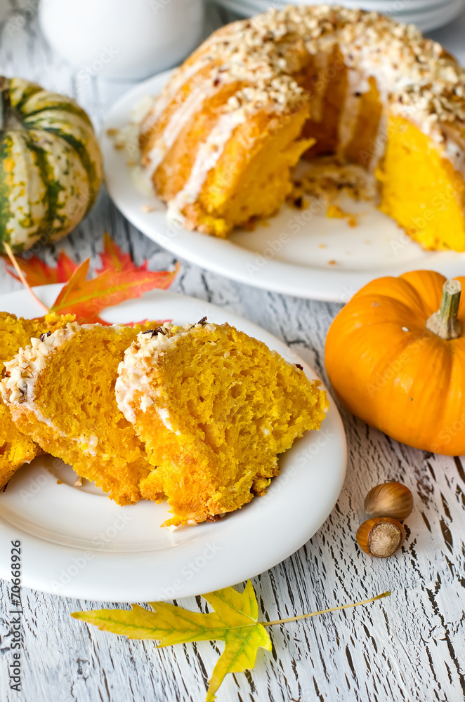Glazed pumpkin cake with hazelnuts on white background Glazed pumpkin cake with hazelnuts on white background