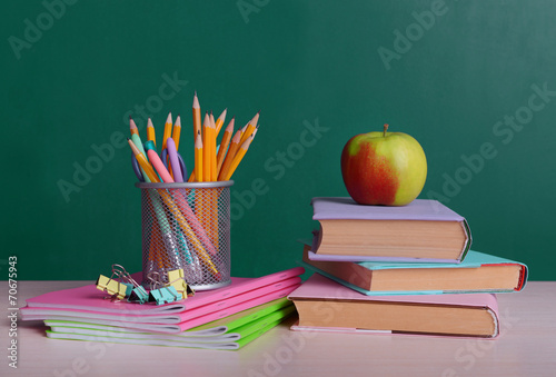 School supplies on table on board background