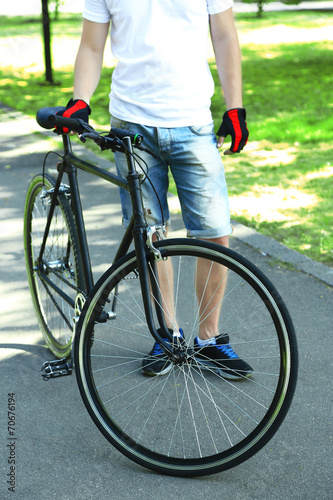 Young man riding bike in city park