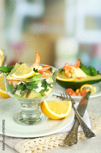 Tasty salads with shrimps and avocado in glass bowl and