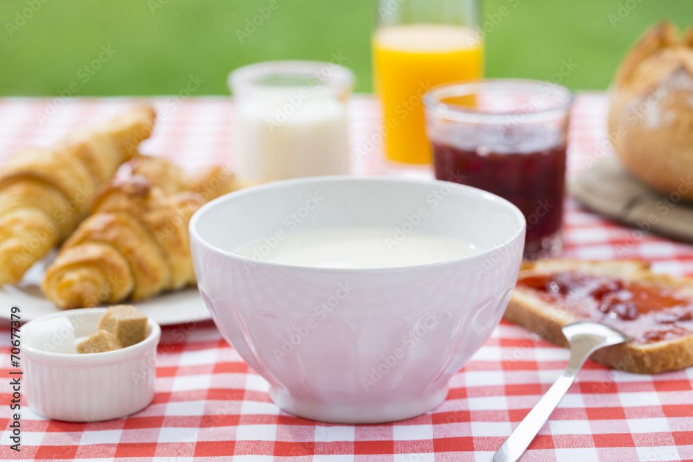 Breakfast with milk, orange juice, croissant, marmalade and brea