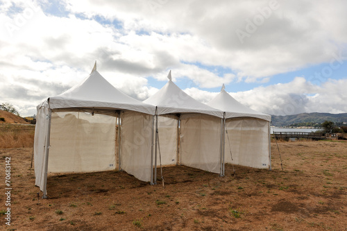White tents in a dry field outdoors © Frank Fennema