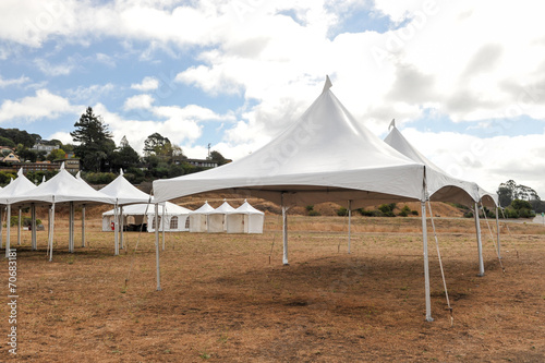 White tents in a dry field outdoors