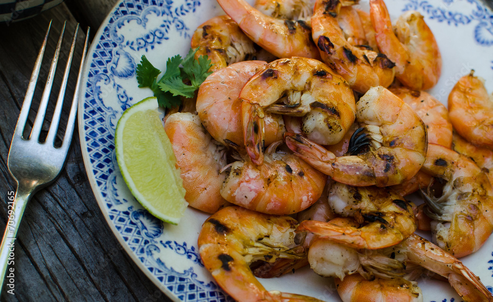 Freshly grilled shrimp on a plate with lime slice