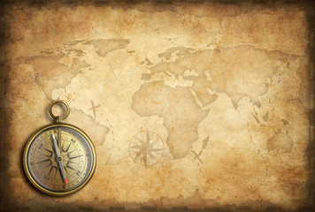 old brass or golden compass with world map background