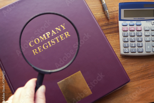 Company Register under magnifying glass photo