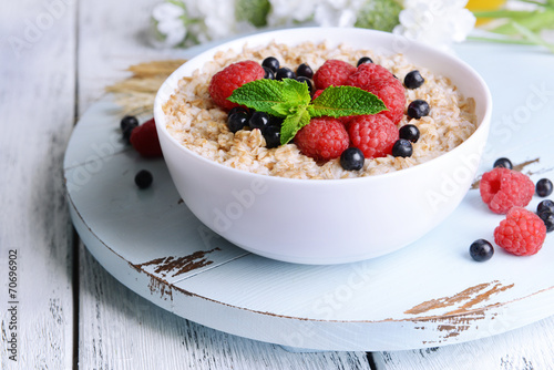 Tasty oatmeal with berries on table close-up