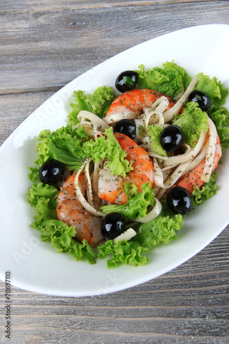 Fresh prawns with spaghetti, olives and lettuce in a white oval