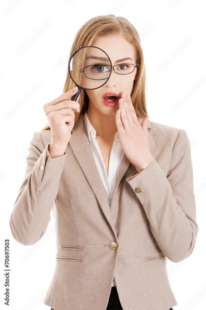 Businesswoman looking into a magnifying glass Businesswoman looking into a magnifying glass
