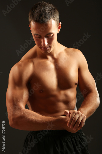Handsome muscle young man on dark background © Africa Studio