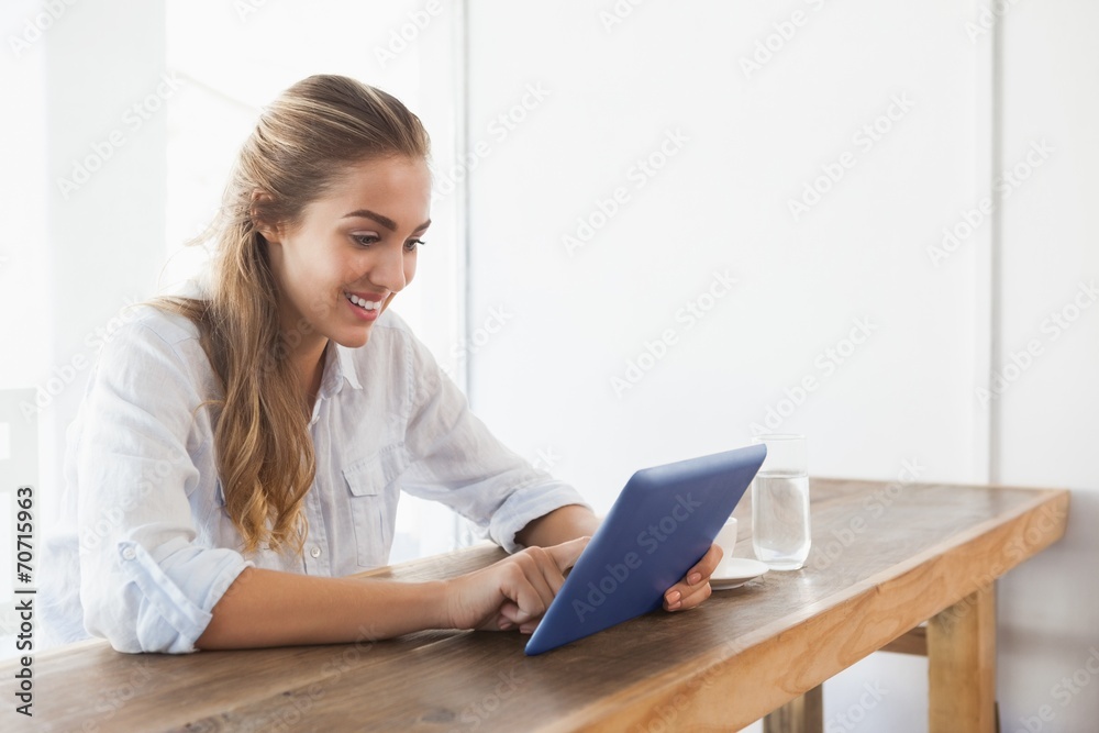 Pretty blonde having coffee while using tablet Pretty blonde having coffee while using tablet