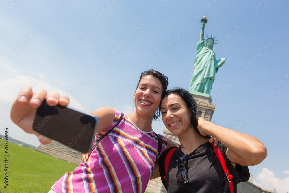 Fototapeta premium Women Taking a Selfie with Statue of Liberty on Background