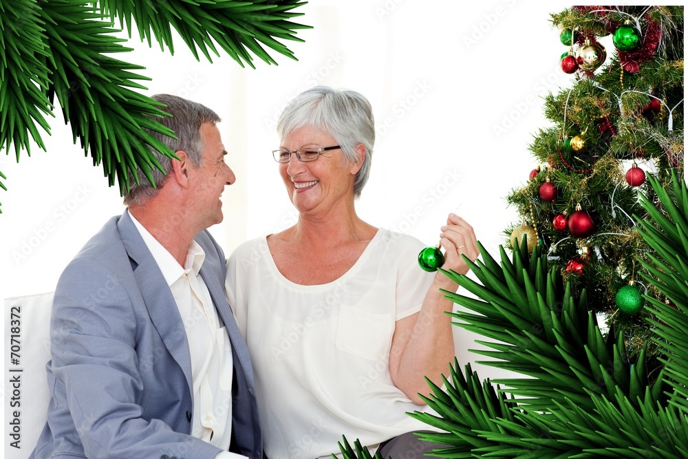 Mature couple sitting on sofa with a christmas tree Mature couple sitting on sofa with a christmas tree