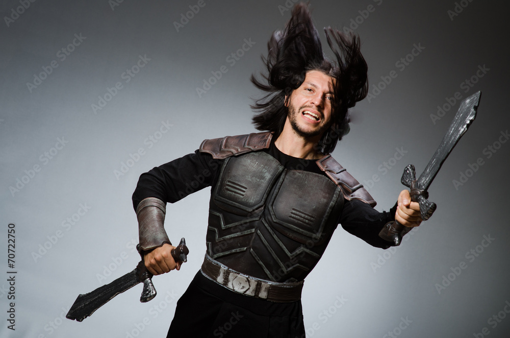 Angry knight with sword against dark background Angry knight with sword against dark background