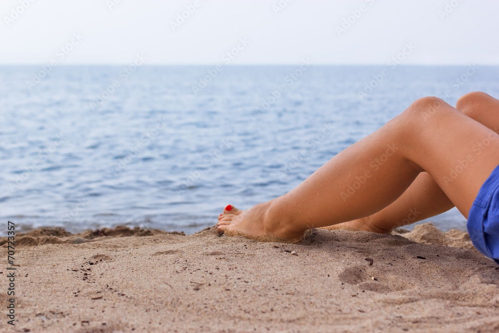 Legs of a young girl on a sandy beach Legs of a young girl on a sandy beach