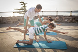 Pilates personal trainer in a group class outdoors