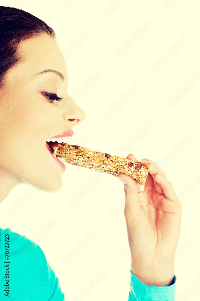 Young woman eating Cereal candy bar Young woman eating Cereal candy bar