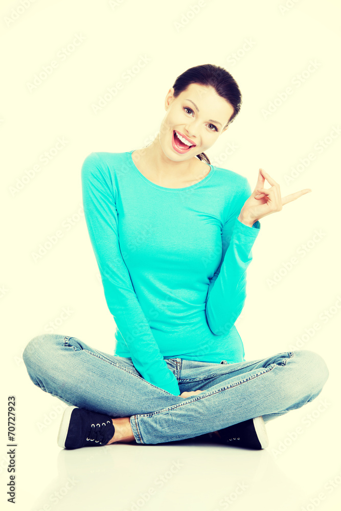Happy , excited young woman pointing on copy space Happy , excited young woman pointing on copy space