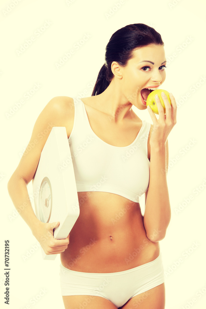 Attractive fit woman with scale and apple